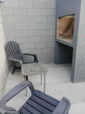a chair and a bench in front of a fireplace at Casa Francesca in Villa Carlos Paz