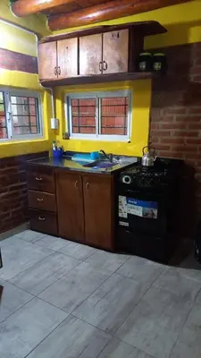 a kitchen with a stove and a yellow wall at Los algarrobos in Mina Clavero