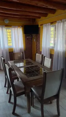 a dining room with a wooden table and chairs at Los algarrobos in Mina Clavero