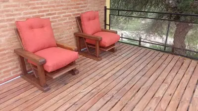 two chairs sitting on top of a deck at Los algarrobos in Mina Clavero
