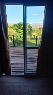 an open door to a deck with a view at Los algarrobos in Mina Clavero