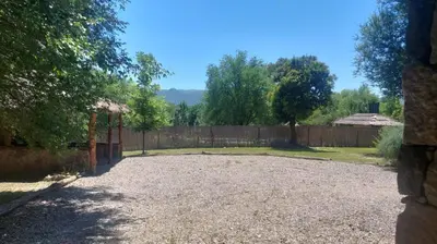 a yard with a fence and a gravel driveway at Cabaña tierra de sueños in Santa Rosa de Calamuchita