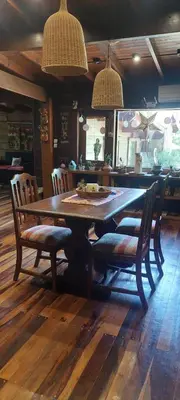 a dining room table with two chairs and a table and two lights at Tierra de Sueños in Santa Rosa de Calamuchita
