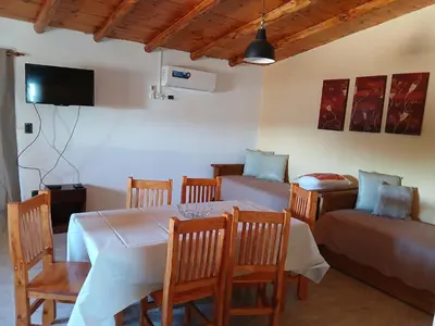 a dining room with a table and chairs and a couch at La soñada in San Antonio de Arredondo