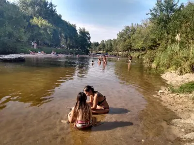 two girls sitting in the water in a river at paprikas in Villa Ciudad Parque