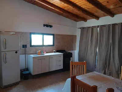 a kitchen with a white refrigerator and a table at La Soñada in Villa Independencia