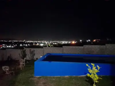 a blue pool on top of a house at night at Brisas de las Sierras 2 in Tanti