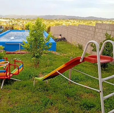 a slide in the grass next to a pool at Brisas de las Sierras 2 in Tanti