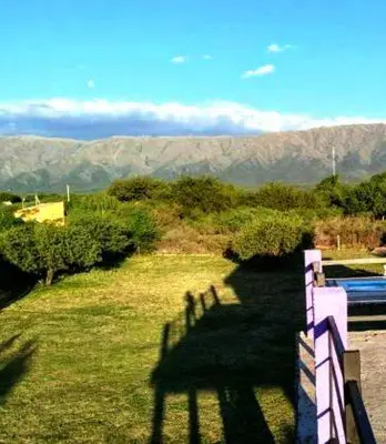 a shadow of a fence on a field with mountains at Casa grande Flor Silvestre in Carpintería