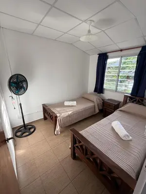 a room with two beds and a fan at Cabañas Marquetti 2 in Potrero de Garay
