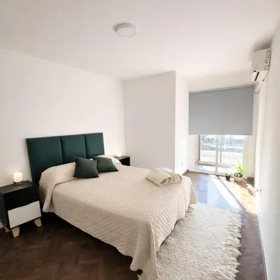 a white bedroom with a large bed and a window at Teacher Grace - Departamento 2 dormitorios en Nueva Córdoba in Cordoba