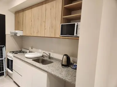 a kitchen with a sink and a microwave at Departamento macrocentro I, espacioso Río Cuarto in Río Cuarto