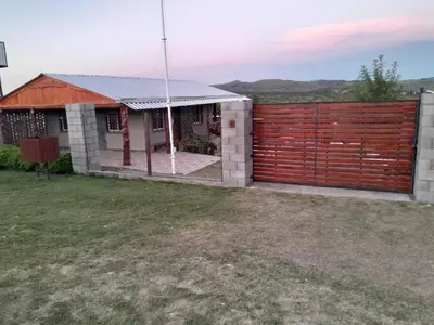 a house with a red fence and a yard at Cabaña de montaña potrero de garay in Potrero de Garay