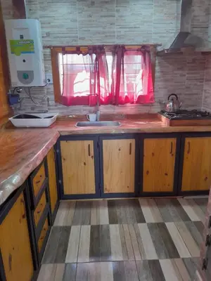 a kitchen with wooden cabinets and a sink at Cabaña de montaña potrero de garay in Potrero de Garay