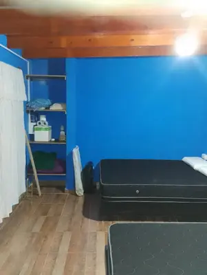 a room with a blue wall and a bed at La Emi in Bialet Massé