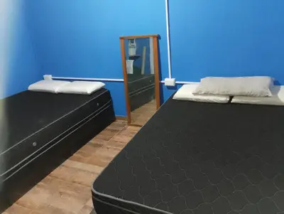 two beds in a room with a mirror at La Emi in Bialet Massé
