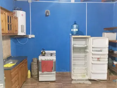 a small kitchen with a stove and a refrigerator at La casona in Bialet Massé