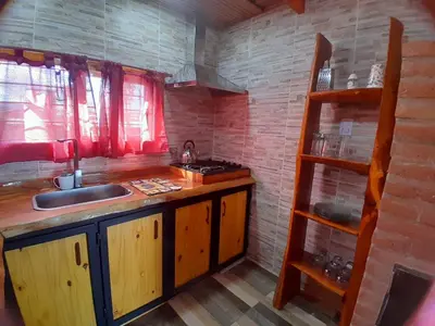 a kitchen with a sink and a counter with a shelf at Mi sueño en la naturaleza in Potrero de Garay