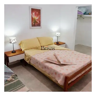 a bedroom with a bed with two lamps on tables at Brisas Departamento Boutique in Villa Carlos Paz