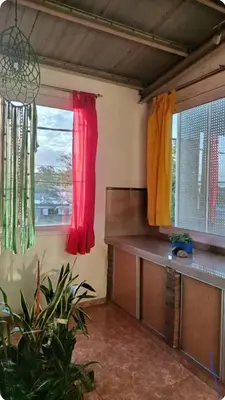 a room with two windows with red and yellow curtains at Depto amoblado in Río Tercero