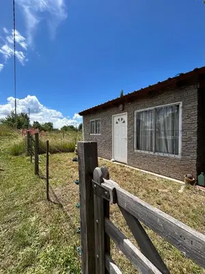 a wooden fence in front of a house at Alma ina in Villa Yacanto