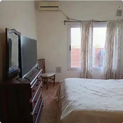a bedroom with a bed and a flat screen tv at Depto wifi rápido con grandes espacios verdes in Río Tercero