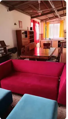 a living room with a red couch and a table at Depto wifi rápido con grandes espacios verdes in Río Tercero