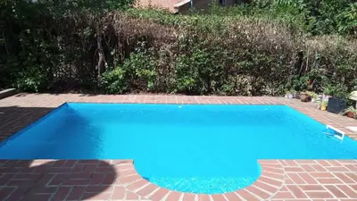 a blue swimming pool with a brick patio at casitadearminda-II in Villa de Las Rosas