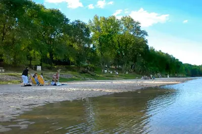 a group of people on a beach near the water at Cabañas Dolce Vita II in Los Reartes