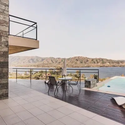 a deck with a table and chairs and a pool at Lake Point Residencias in Villa Parque Siquiman