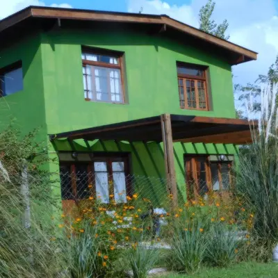 a green house with windows and flowers in front of it at Celandine in Los Reartes