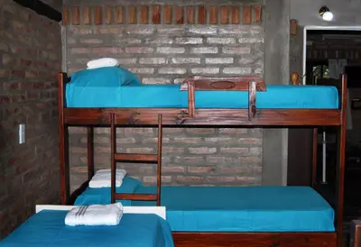 two bunk beds in a room with blue sheets at Cabanas en el Jardin Nativo in San Francisco del Monte de Oro
