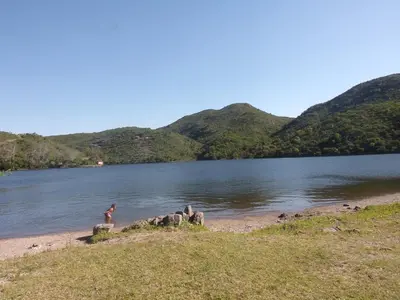 a person standing on the shore of a lake at La casona Segunda Usina in Embalse