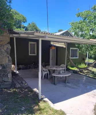 a covered patio with a table and a bench at La casona Segunda Usina in Embalse