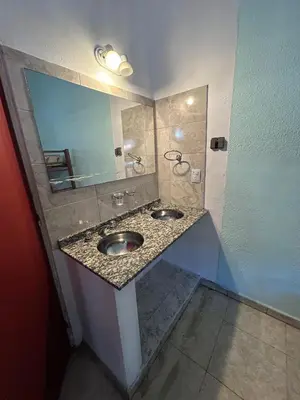 a bathroom with two sinks and a mirror at Central Paz Hostel in Villa Carlos Paz