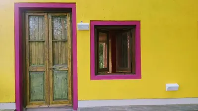a yellow building with two doors and windows at apartamento VINTAGE IVA in Merlo