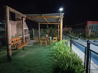 a patio with a table and chairs at night at Cabañas Dayma in Trapiche