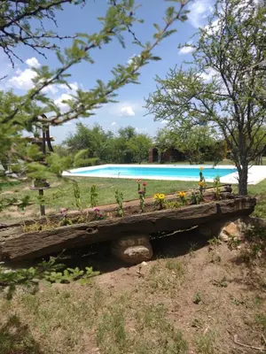 a wooden bench filled with flowers next to a swimming pool at Valle de Fatima in Villa de Las Rosas