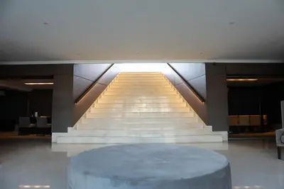 a large staircase with a round table in a building at Apart France - Con gim, piscina y estacionamiento in Río Cuarto