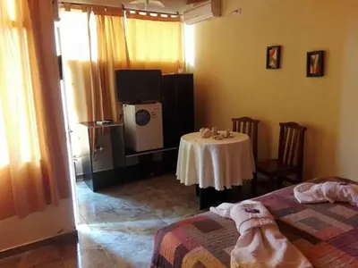 a room with a table and a tv in a room at Complejo Mirador de las Sierras pileta climatizada al aire libre in San Javier