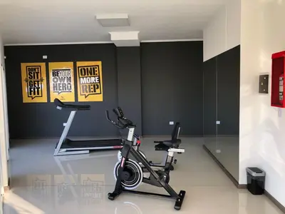 a gym with a treadmill and a bike in a room at Edificio Veneto IV - Departamento de un dormitorio en pleno centro in Villa Carlos Paz