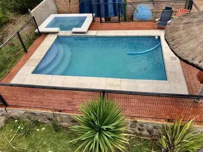 a large swimming pool in a backyard with a table and a table at LA MILAGROS PIQUITO DE ORO in Merlo