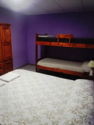 a bedroom with two bunk beds and a purple wall at Complejo de Departamentos DON QUIJOTE in Almafuerte