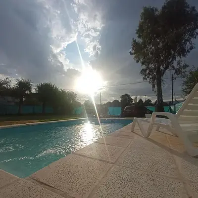 a white chair sitting next to a swimming pool at El Abuelo in Santa Rosa de Calamuchita
