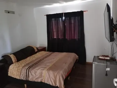 a bedroom with a bed and a black curtain at Hermosa casa en Lomas Del Rey in San Antonio de Arredondo