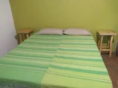 a green bedroom with a bed with two chairs at Casa Alma Verde armonia in Luyaba
