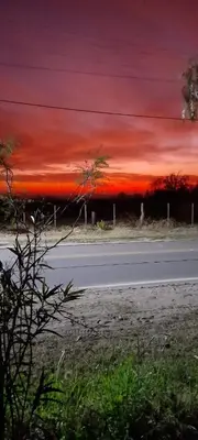 a road with a red sunset in the sky at Casa Alma Verde armonia in Luyaba