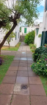 a sidewalk in front of a building with a tree at Castillo Del Lago - Carlos Paz - dep17 in Villa Carlos Paz