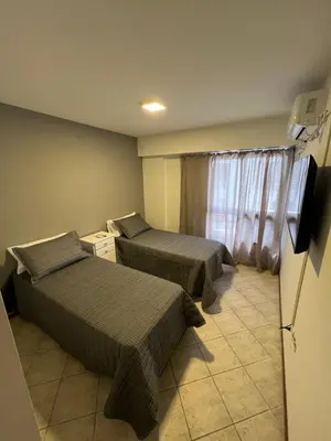 a hotel room with two beds and a television at SUPER UBICACIÓN NUEVA CÓRDOBA in Cordoba